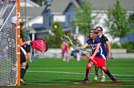 June 04, 2011 OGLA (Oregon Girls Lacrosse) Hillsboro Oregon 53rd street tournament for 5-6th grade girls. 8:00am Westview V HALO, Westview player #22 takes a shot on the goal as HALO's goalie tries to move into position to block.  Final score 5-3 Westviewのeditorial素材