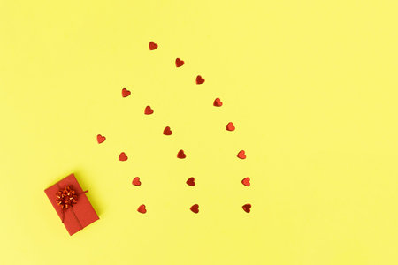 Wi Fi shape made of red gift box and hearts on yellow background. Minimal love concept. Flat lay ...
