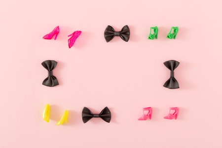 Minimal frame made with black bow ties and colorful heels on bright pink background. Creative party...