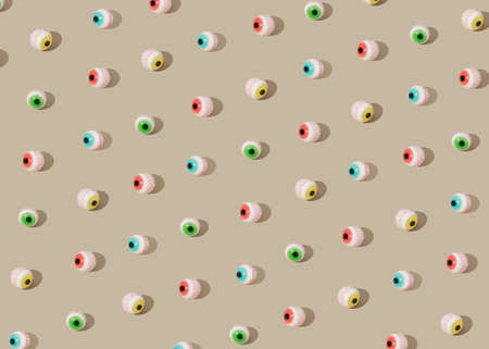 Halloween pattern made with colorful eyeball candies. Creative spooky concept. Autumn holiday fun idea.の写真素材