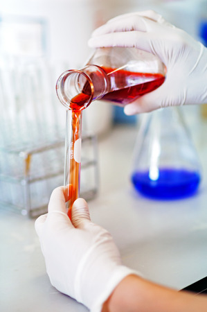 Test-tubes with solutions blood in hand of scientistの写真素材