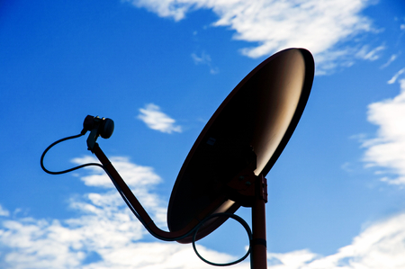 silhouette Satellite dish againts blue skyの写真素材