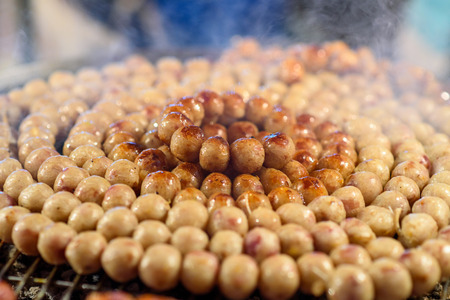 Thai style sausage grilling on stove at night marketの写真素材