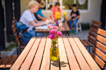 Flowers in Jar on wooden table at street cafe , Chiang mai ,Thailandの写真素材