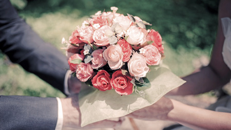 Bride and groom's holding flowers wedding bouquet in handsの写真素材