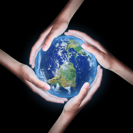 Four hands save the world on black background ,Elements of this image furnished by NASAの写真素材