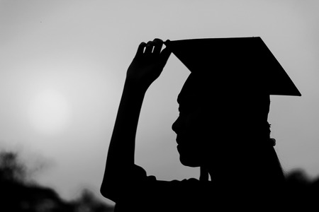 Silhouette of graduate woman in sunset , black and whiteの写真素材