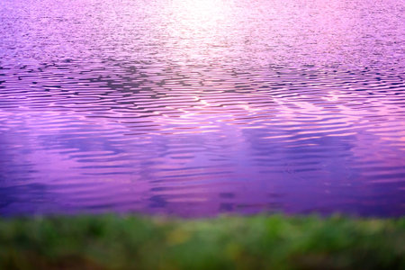 close-up background texture blurred image of waves on purple lake at sunsetの写真素材