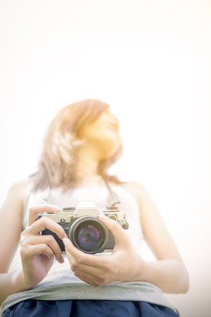 Hipster girl holds camera in gardenの写真素材