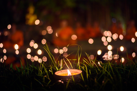 vintage style candle cup in Thai temple at night with monk backgroundの写真素材