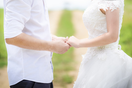 Bride and Groom Holding Hands outdoorsの写真素材