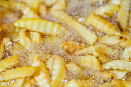 close up French Fries Potatoes cooking in basket of Frying Machine , deep fried in Hot Boiling Oilの写真素材