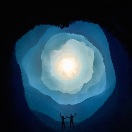 Happy man and woman hikers trekking in blue mountains layers during sunsetの写真素材