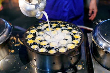 making of " Khanom khrok " Coconut-rice pancakes on iron panの写真素材
