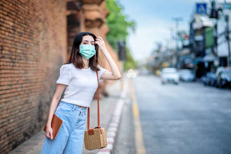 young  beautiful asian woman showing how to wear a medical mask or  showing how to correctly wear hygiene surgical mask step by step on white backgroundの写真素材