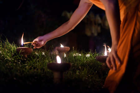 Buddhist monk hands lighting candle lighting candle  in dark ,Chiang mai , Thailandの写真素材