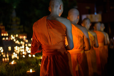 Buddhist monk hands holding candle cup in the dark   ,Chiang mai , Thailandの写真素材