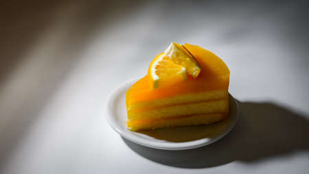 orange cake with orange topping on white plateの写真素材