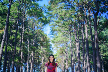 happy woman touristraised hand in pine forestの写真素材
