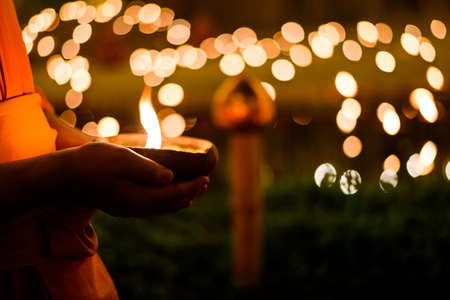 Buddhist monk hands holding candle cup in the dark, Chiang mai , Thailandの写真素材