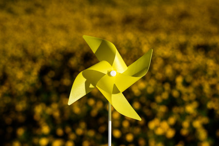 yellow paper windmill in flower garden background