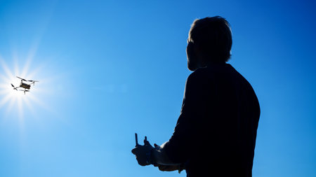 Silhouette of man using drone in blue sky  for photos and video makingの写真素材