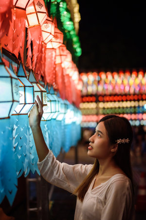 Beautiful asian girl holding paper lantern in the street at nightの写真素材