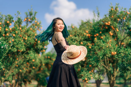 happy asian woman greeny hair in organic orange plantation gardenの写真素材