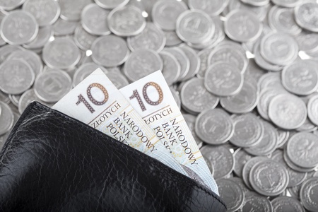Black wallet with ten polish zloty paper money laying on one polish zloty coins. Money and savings concept.の写真素材