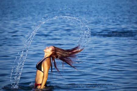 Beautiful young woman splashing water in sea. Rhodes Faliraki during summer.の写真素材