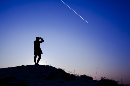 Young woman standing on the top of the hill during winter sunset  Backlight landscape 