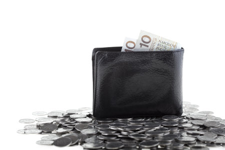 Black wallet with ten polish zloty paper money laying on one polish zloty coins isolated on white...