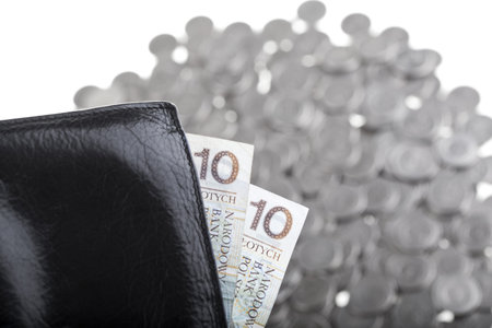 Black wallet with ten polish zloty paper money laying on one polish zloty coins isolated on white...