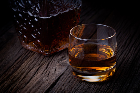 Glass of luxury single malt whiskey  Drink and bottle composition photography taken on old wooden table の写真素材