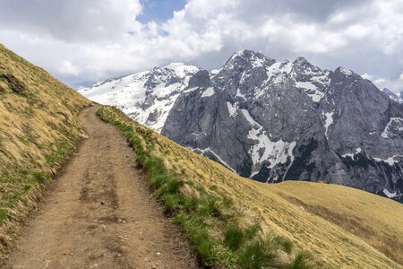 Mountain trail with a view of the Marmolada massif. Dolomites. Italy.の写真素材