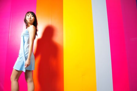 Asian Woman Walking By Colourful Backgroundの写真素材