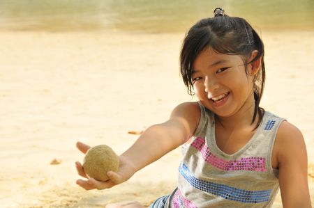 Little Asian Girl Playing Sand By The Beach の写真素材