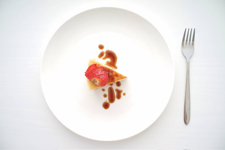 close up of a small slice of cheese cake with strawberry toppings. Useful for food related themeの写真素材