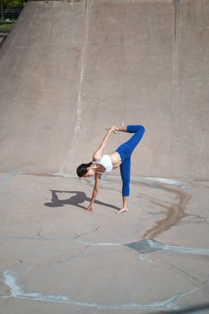 yoga in public spaces, Asian Chinese Woman does Yoga in public skate park