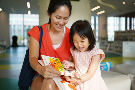 Asian Chinese Mother and Daughter visiting the library and browsing through books