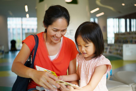 Asian Chinese Mother and Daughter visiting the library and browsing through books