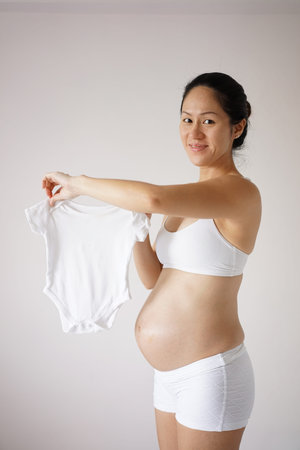 Asian Chinese Pregnant Woman feeling discomforts caused by pregnancy