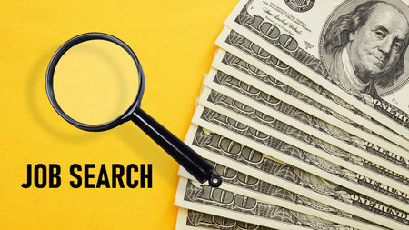Job Search is shown using a text and photo of dollars and magnifying glassの写真素材