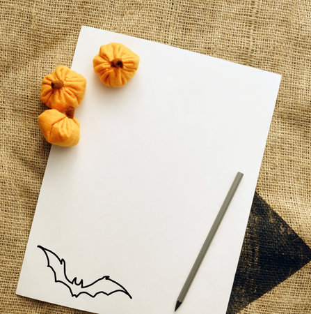 Halloween stationery composition. Mockup scene with blank greeting card invitation. Little orange pumpkins handmade. Burlap background in sunlight. Autumn, Thanksgiving concept. Top viewの写真素材