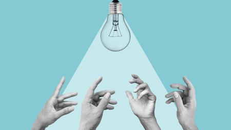 Hands reaching for a light bulb as metaphor of ideas, work and achievement. Fresh ideas inspiration conceptsの写真素材