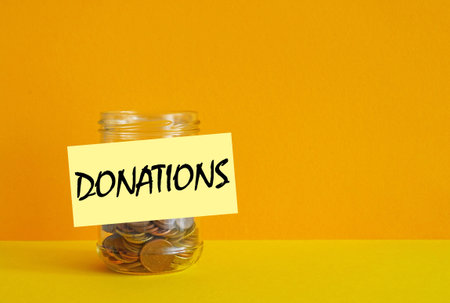 Donations concept is shown by Coins in glass jar for giving. Concept of charity, love, donate