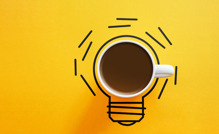 Creativity and a new idea are shown by cup of coffee and a light bulb. A fresh cup of coffee for a positive mindsetの写真素材