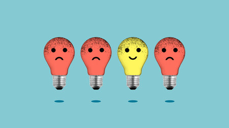 Positive thinking and choosing good ideas over negative thinking are shown by Light bulbs with emoticons inside with a positive and negative expressionの写真素材