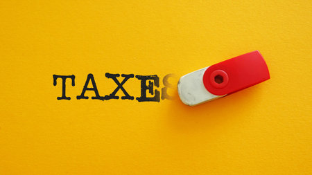 Tax reduction is shown with the erasing word Taxesの写真素材