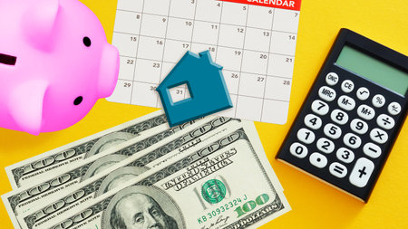 Monthly Budget and paying rents for housing. Piggy bank, house figurine with monthly calendar and...